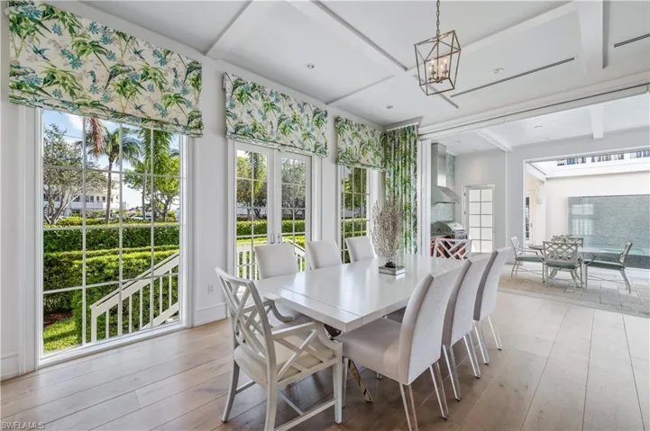 Dining area with french doors, coffered ceiling, an inviting chandelier, light hardwood / wood-style flooring, and beamed ceiling