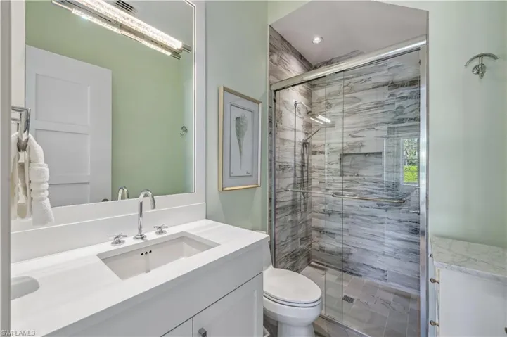 Bathroom with vanity, toilet, and walk in shower