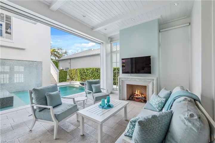 View of patio featuring an outdoor living space with a fireplace and a fenced in pool