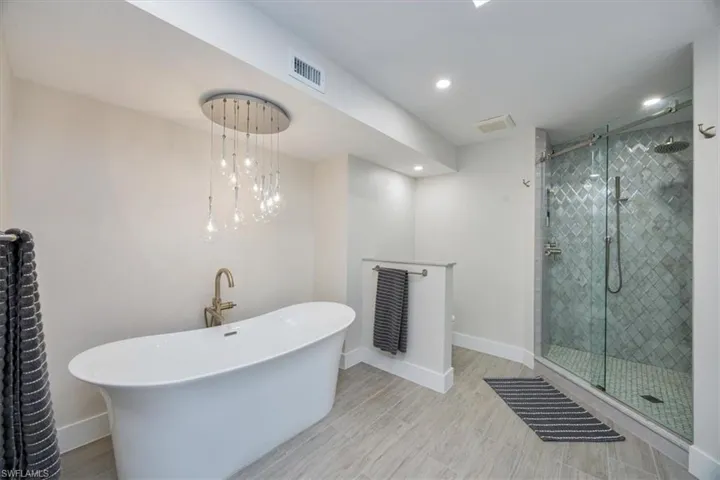 Bathroom featuring wood-type flooring and independent shower and bath