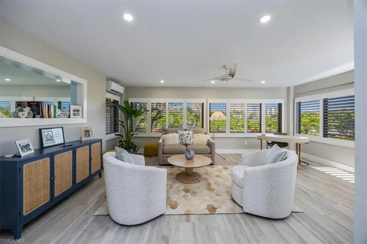 Den/office with ceiling fan, light hardwood / wood-style floors, and a wall unit AC