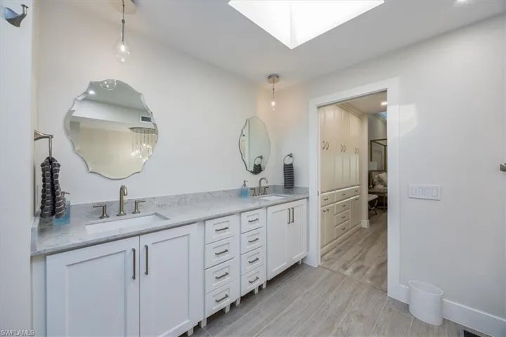 Bathroom featuring vanity, a skylight, and wood-type flooring