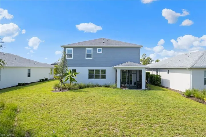 Rear view of property featuring a yard and water view