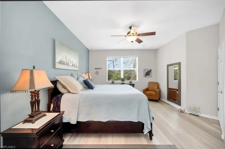 Large primary suite with serene tones, wood-look flooring, and generous walk-in closet.