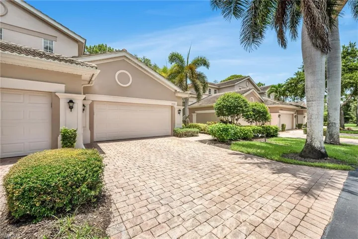 Beautifully maintained exterior with tropical landscaping and paver driveway welcomes you home.