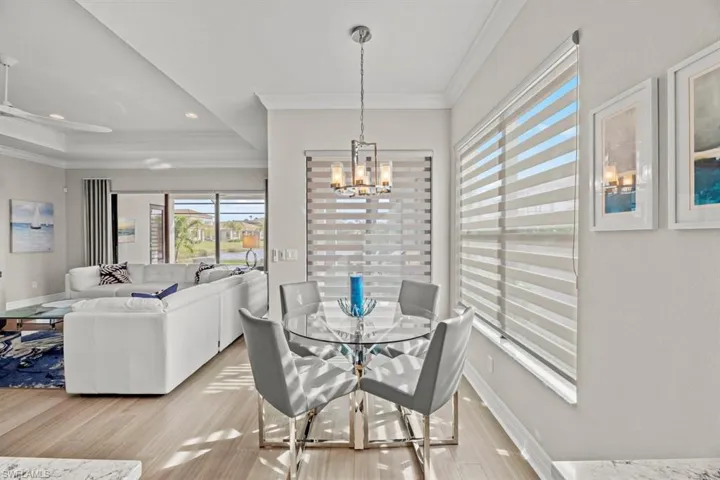 Dining room with a chandelier, crown molding, and light hardwood / wood-style flooring