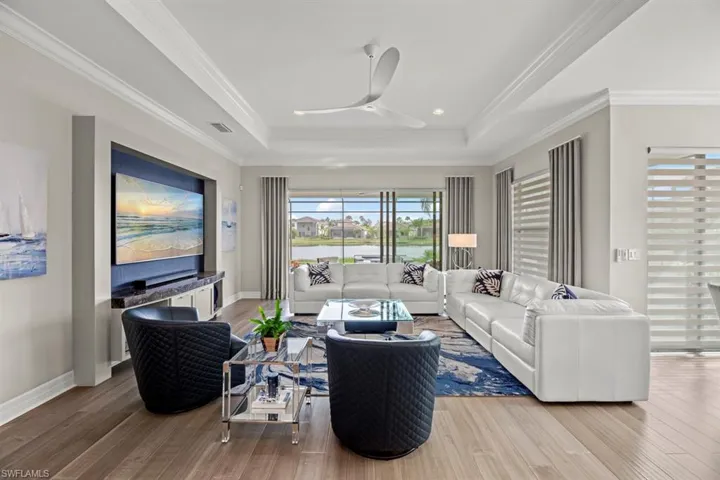 Living room featuring ornamental molding, hardwood / wood-style flooring, and ceiling fan