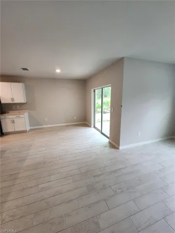 Unfurnished living room featuring wood tiled floors and recessed lighting
