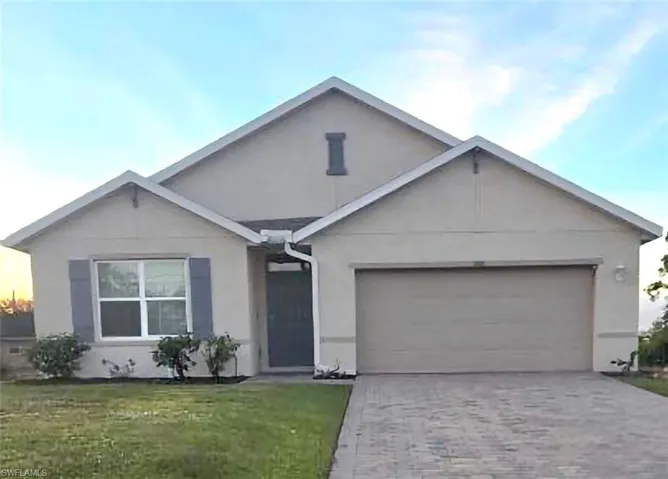 Ranch-style house with stucco siding, decorative driveway, a front yard, and an attached garage