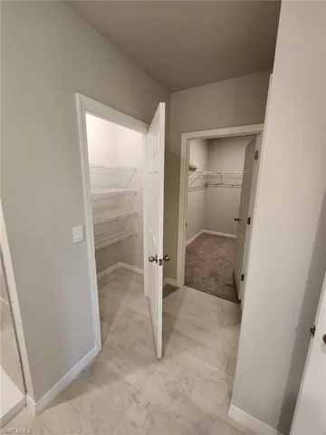 Bathroom with a walk in closet and baseboards