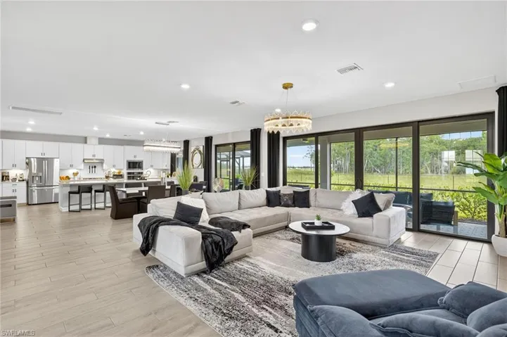 Living area with plenty of natural light, a chandelier, light wood-style flooring, and recessed lighting