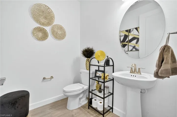 Half bath featuring toilet and wood finished floors
