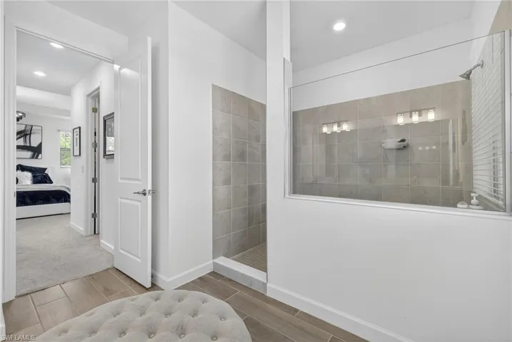 Ensuite bathroom featuring a walk in shower, wood tiled floors, and recessed lighting