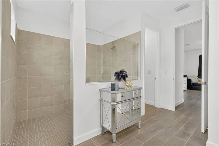 Full bathroom featuring a walk in shower, wood finish floors, and ensuite bathroom
