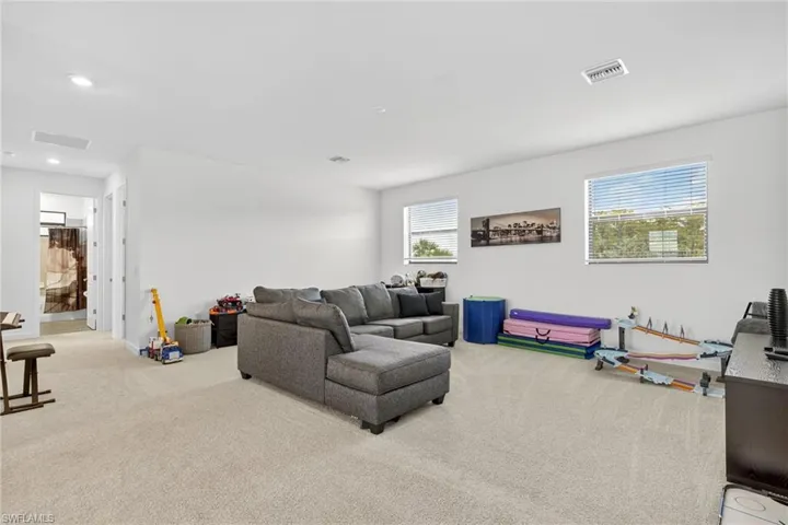 Carpeted living room featuring recessed lighting and baseboards