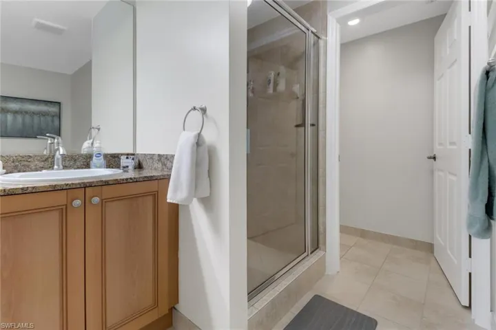 Bathroom with tile patterned flooring, vanity, and a shower with shower door
