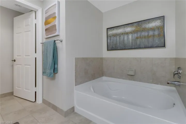 Bathroom with a bathing tub and tile patterned floors