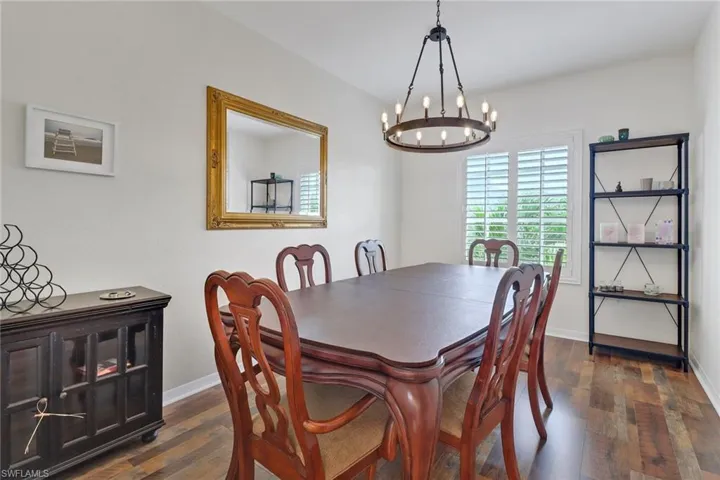 Dining area with a notable chandelier and dark hardwood / wood-style flooring