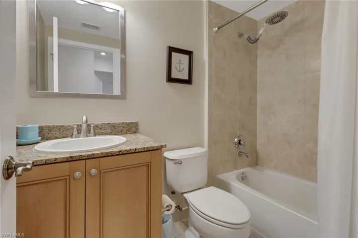 Full bathroom featuring shower / bath combination with curtain, toilet, and vanity