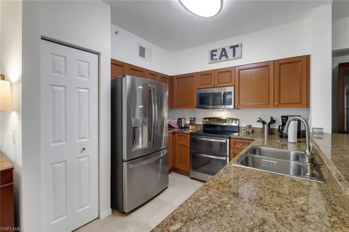 Kitchen with appliances with stainless steel finishes, sink, and light tile patterned flooring