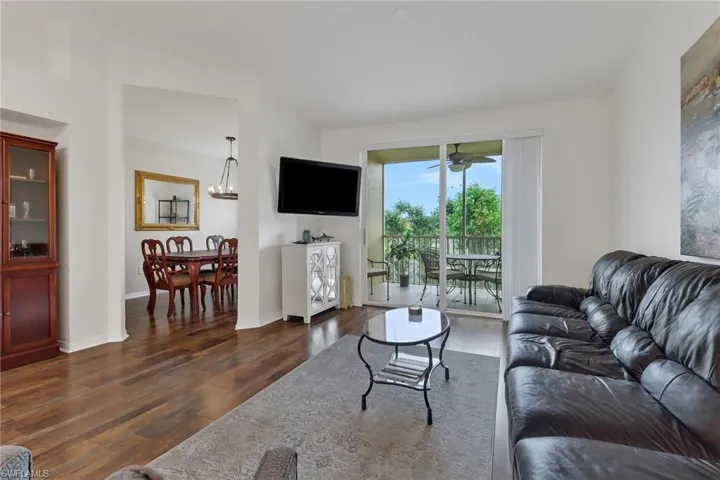 Living room featuring dark hardwood / wood-style floors and ceiling fan with notable chandelier