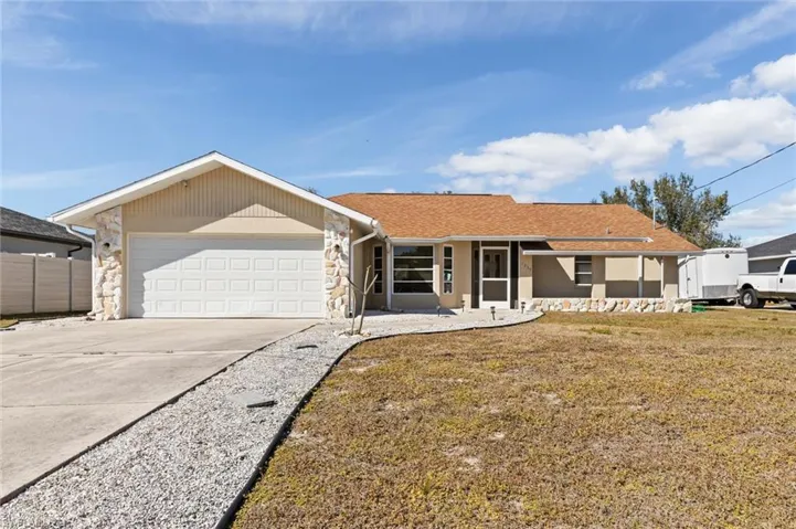 Ranch-style house with stone siding, driveway, a garage, and a shingled roof