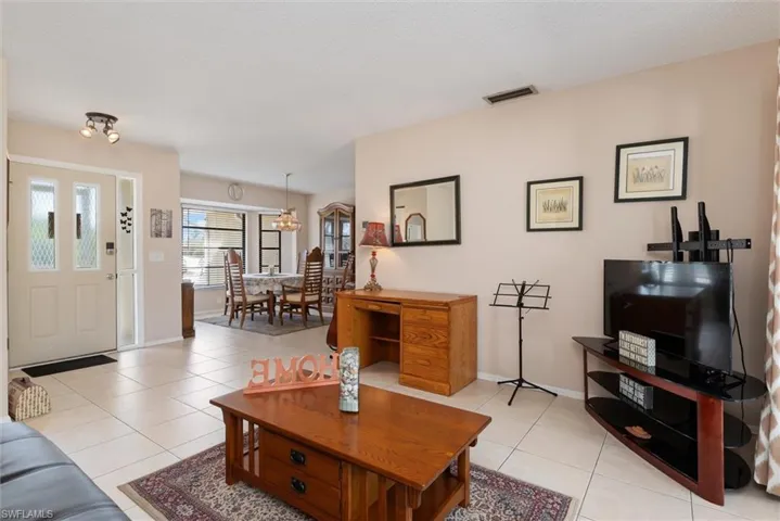 Living room with light tile patterned floors and a chandelier