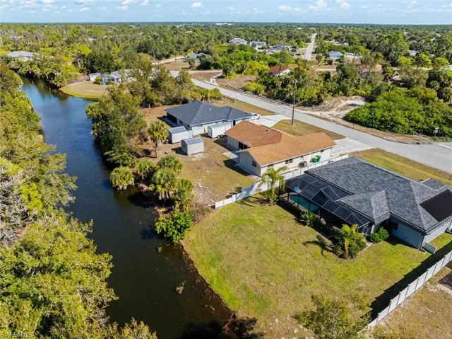 Aerial overview of property's location with a nearby body of water and a tree filled landscape