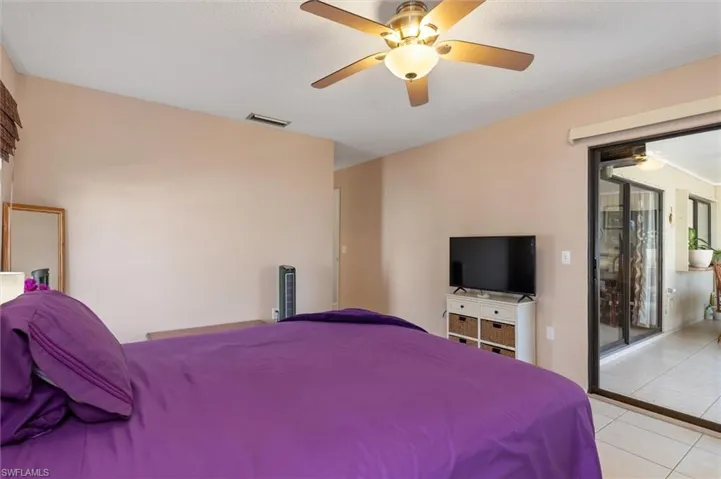 Bedroom featuring access to outside, a ceiling fan, and light tile patterned flooring