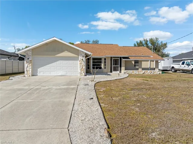 Ranch-style house featuring stone siding, concrete driveway, a garage, and roof with shingles