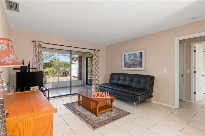 Living room with light tile patterned floors and baseboards