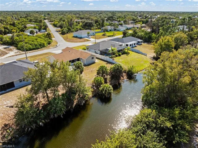 Aerial view of property and surrounding area with a nearby body of water and nearby suburban area