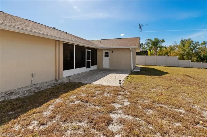 Back of property featuring a fenced backyard, stucco siding, a patio, a sunroom, and roof with shingles