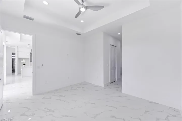 Unfurnished room with a raised ceiling and ceiling fan