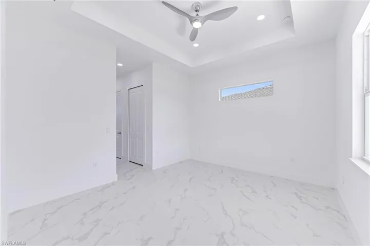 Empty room featuring a raised ceiling and ceiling fan