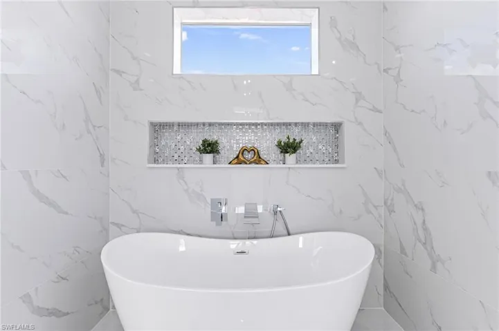 Bathroom with a tub to relax in and tile walls
