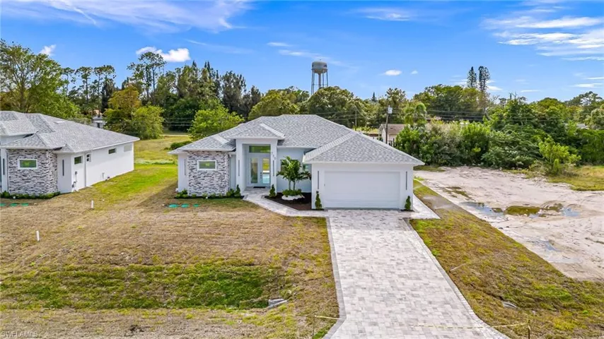 View of front of property featuring a front yard and a garage