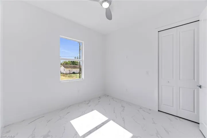 Unfurnished bedroom with ceiling fan and a closet