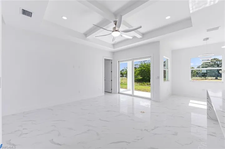 Spare room featuring beam ceiling, a raised ceiling, and ceiling fan