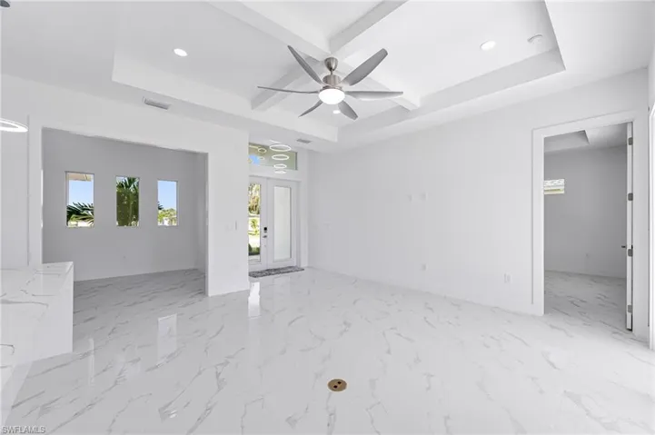 Unfurnished room with ceiling fan and a raised ceiling