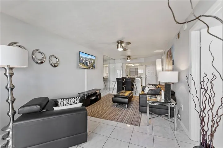 Living area featuring ceiling fan and tile patterned flooring