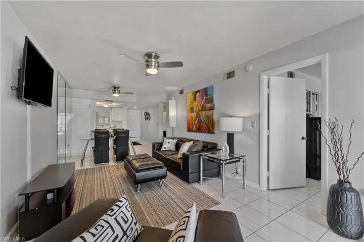 Living room with light tile patterned floors and ceiling fan