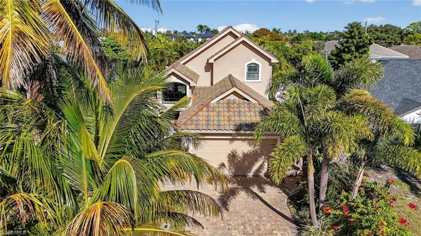 View of front of property featuring stucco siding, a garage, and decorative driveway