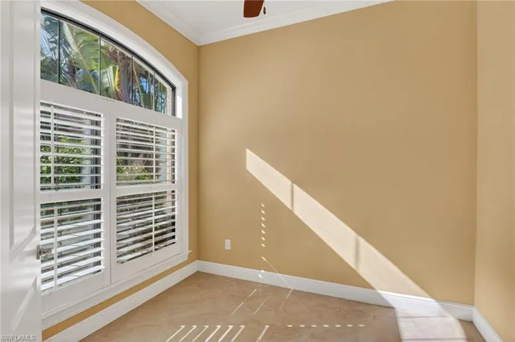 Spare room featuring ornamental molding and a ceiling fan