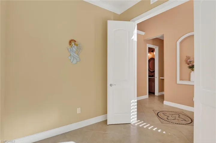 Spare room with ornamental molding and light tile patterned floors