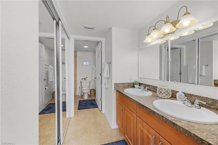 Bathroom featuring double vanity and light tile patterned flooring