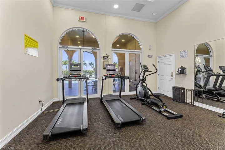 Workout area featuring a high ceiling, recessed lighting, and ornamental molding