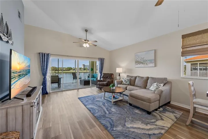 Living room featuring ceiling fan, wood finished floors, plenty of natural light, and high vaulted ceiling