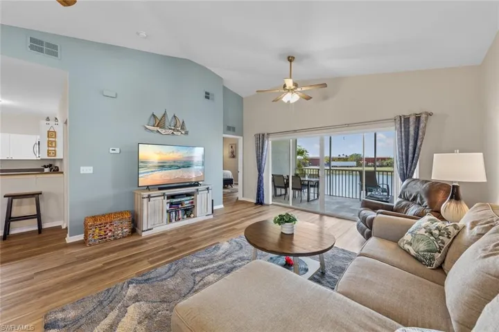 Living area featuring ceiling fan, wood finished floors, and high vaulted ceiling