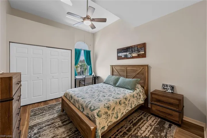 Bedroom featuring wood finished floors, a closet, and a ceiling fan